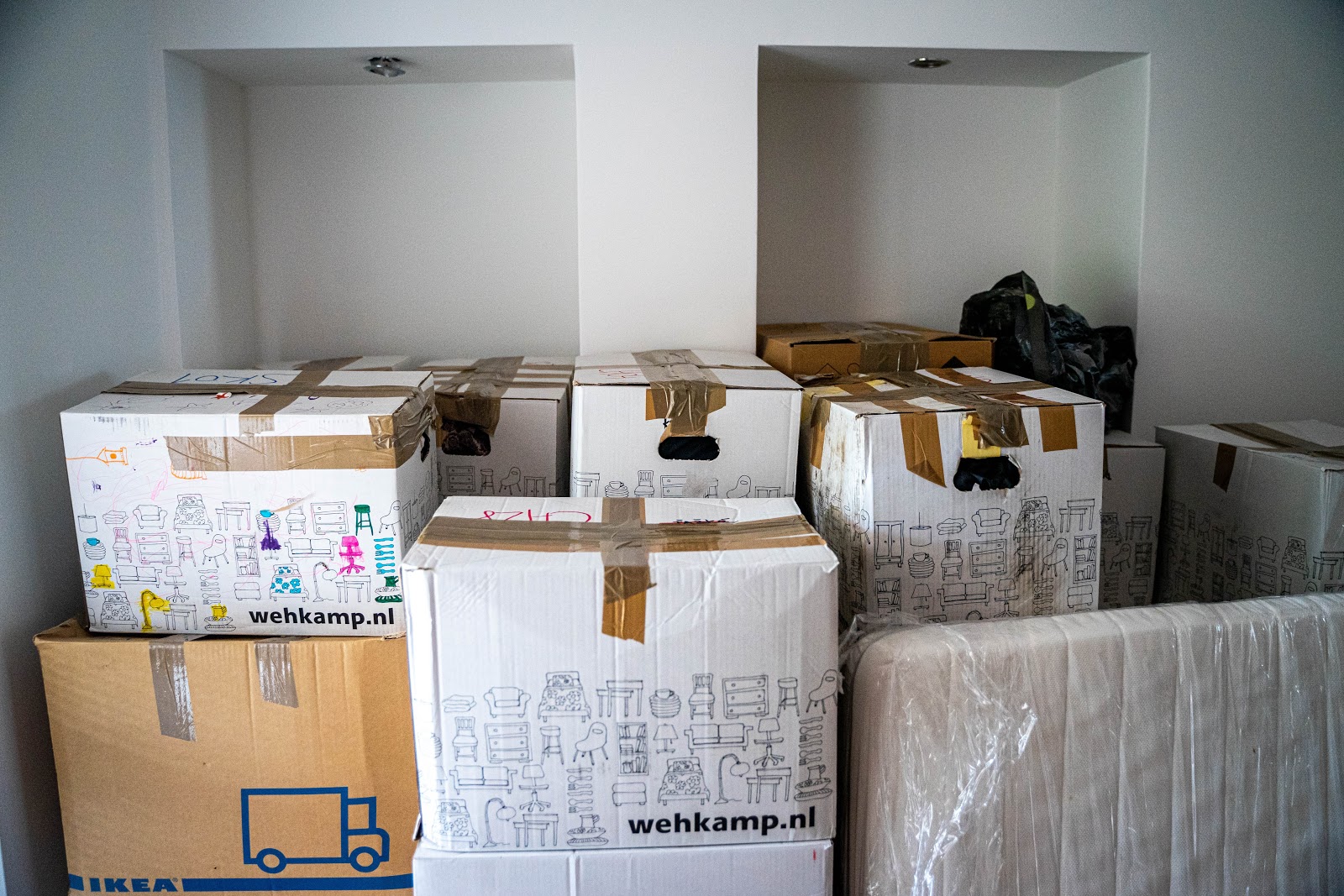 Umzugskartons in einem leeren Raum gestapelt, bereit für den neuen Wohnungsbeginn in der Schweiz. Perfekte Organisation für einen reibungslosen Umzug.